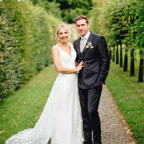 Bride-and-groom-on-pleached-walkway-at-Homme-House