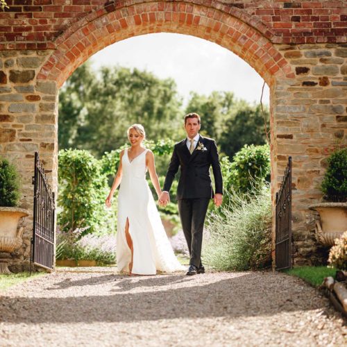 Bride-and-groom-outside-walled-garden-entrance-at-Homme-House