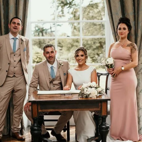 Bride-and-groom-sign-marriage-register-with-witnesses