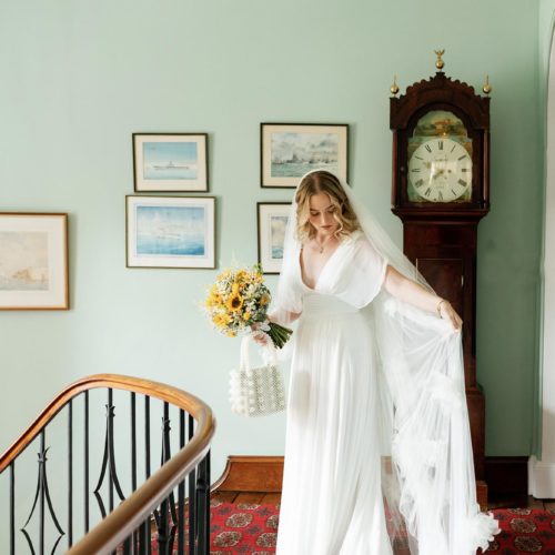 Bride-at-top-of-Homme-House-staircase-arranging-veil