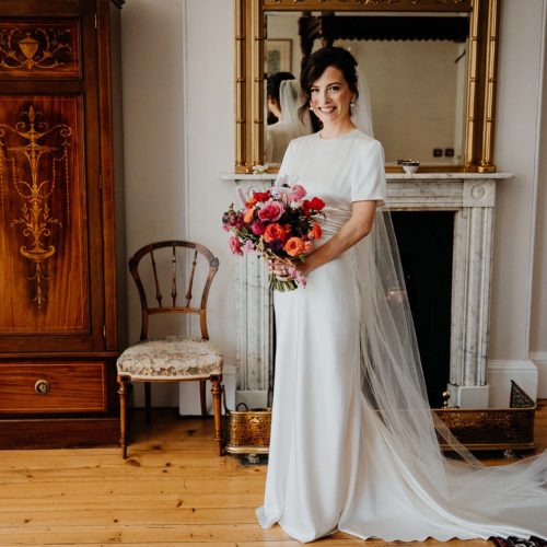 Bride-poses-with-bouquet-in-front-of-wardrobe