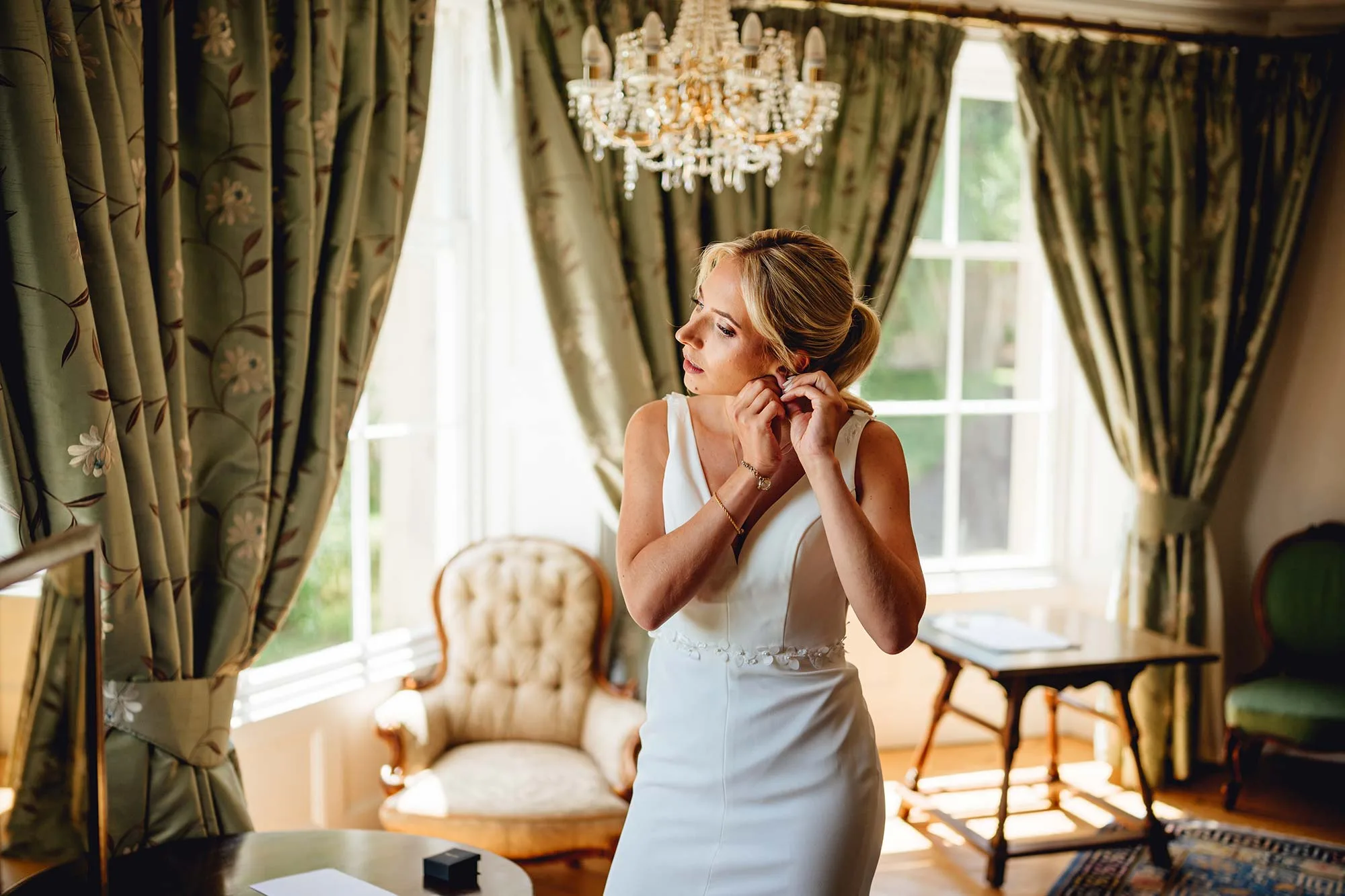 Bride-puts-earrings-on-in-Homme-House-Bridal-Suite