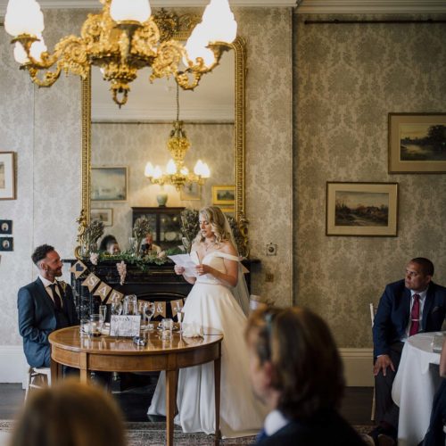 Bride-reads-wedding-speech-in-front-of-Homme-House-dining-room-mantelpiece