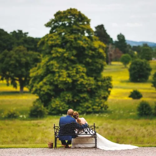 Couple-look-out-across-Homme-House-parkland-from-bench