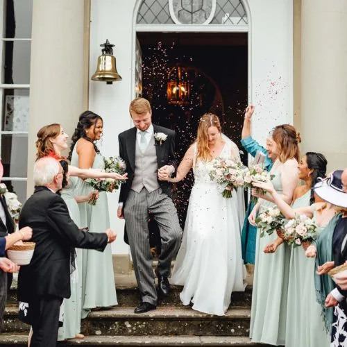 Couple-showered-with-confetti-on-the-steps-at-Homme-House