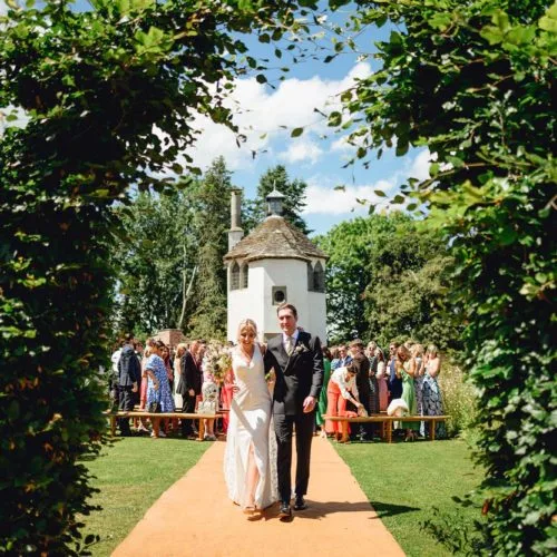 Couple-walk-aisle-at-end-of-Homme-House-outdoor-wedding-ceremony