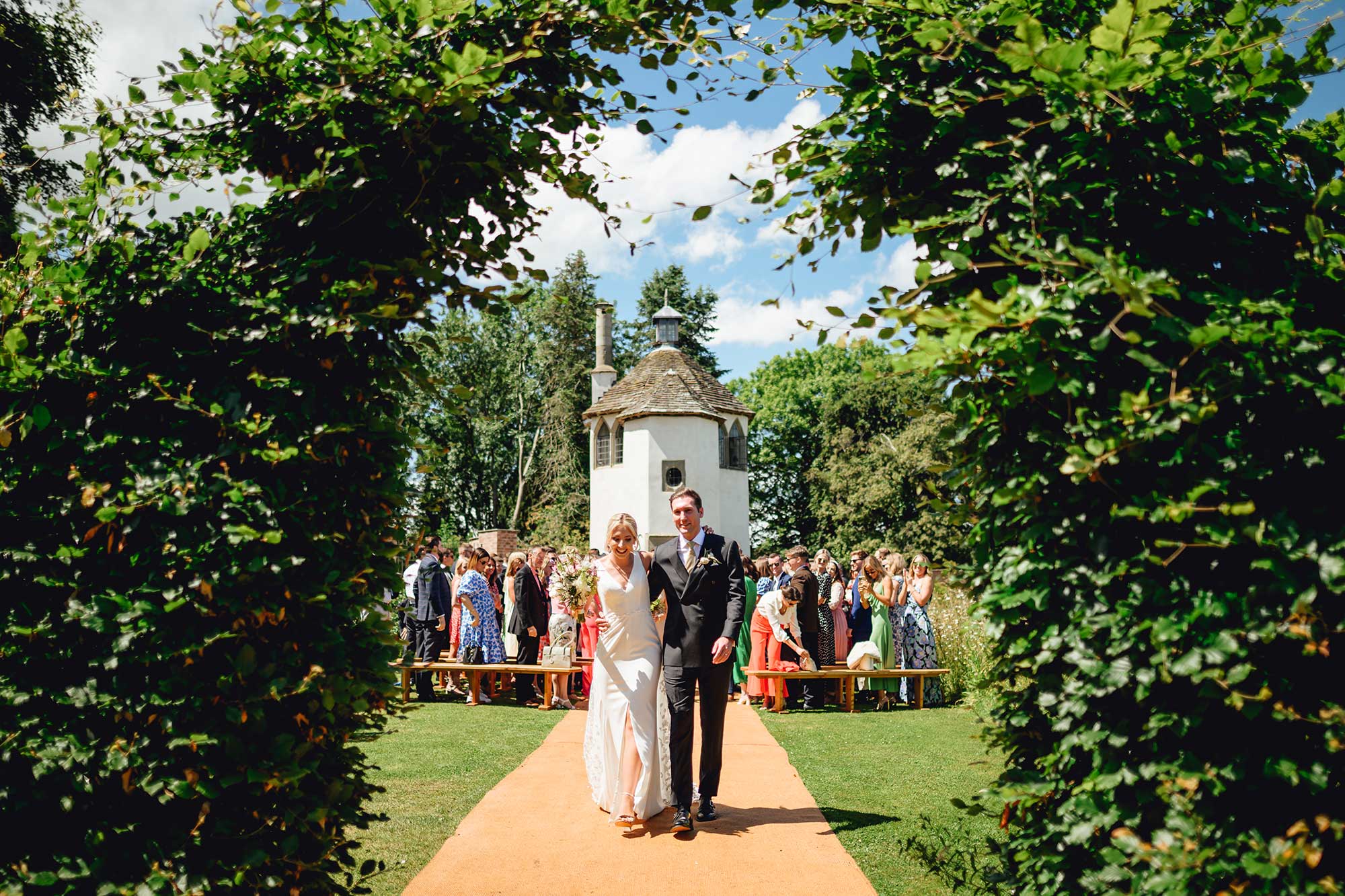 Couple-walk-aisle-at-end-of-Homme-House-outdoor-wedding-ceremony