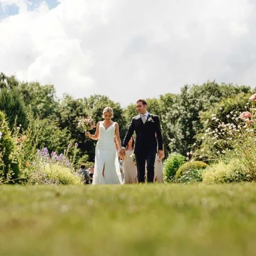 Couple-walk-through-walled-garden-at-Homme-House