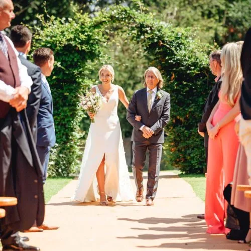 Entrance-of-bride-at-Homme-House-walled-garden-wedding-ceremony
