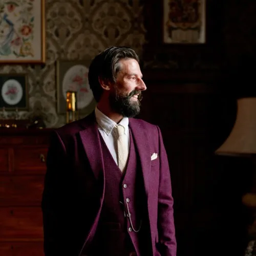Groom-poses-by-window-in-Library-at-Homme-House