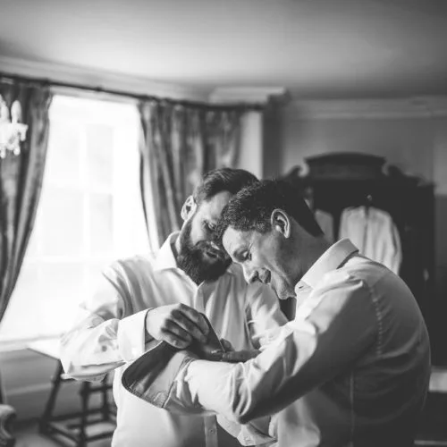 Grooms-adjust-cufflinks-in-Homme-House-Main-Suite