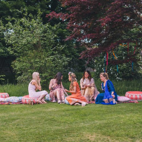 Guests-sitting-on-bank-above-main-lawn-at-Homme-House-wedding-reception