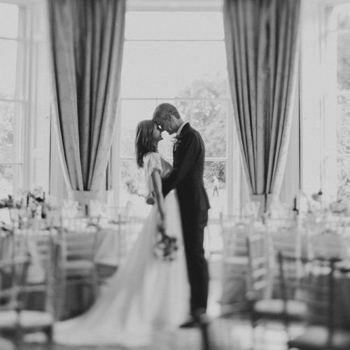 Romantic-black-and-white-couple-portrait-with-Homme-House-bay-window-in-background