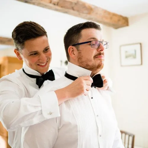 Two-men-put-on-bowties-in-Homme-House-Coach-House