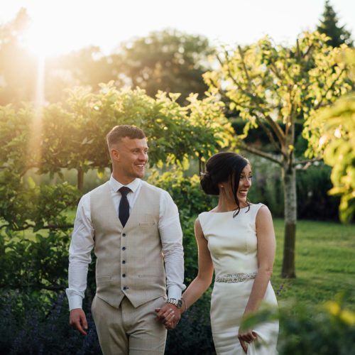 Wedding-couple-walking-in-Homme-House-walled-garden-in-evening-sunshine