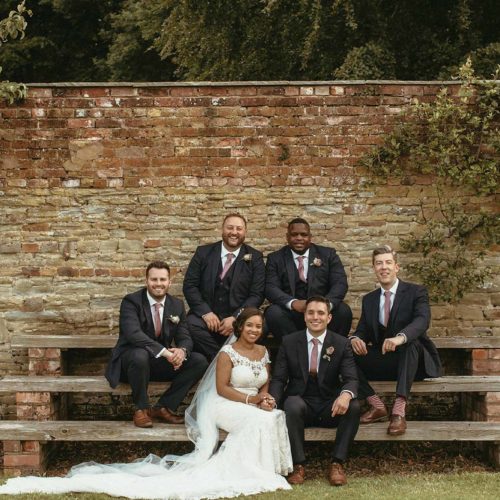 Wedding-group-photograph-on-steps-beside-wall