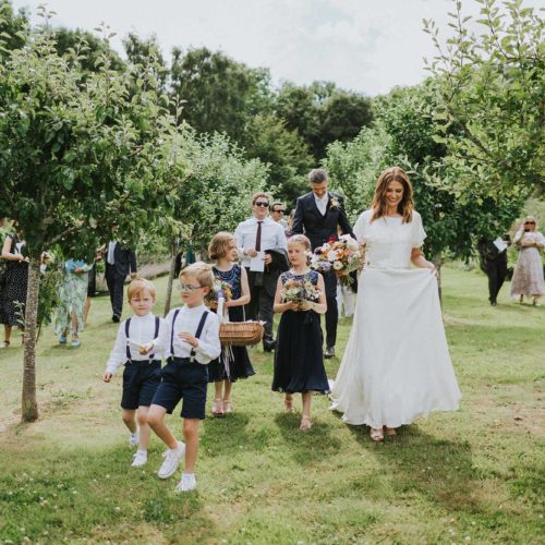 Wedding-party-walking-through-orchard-at-Homme-House