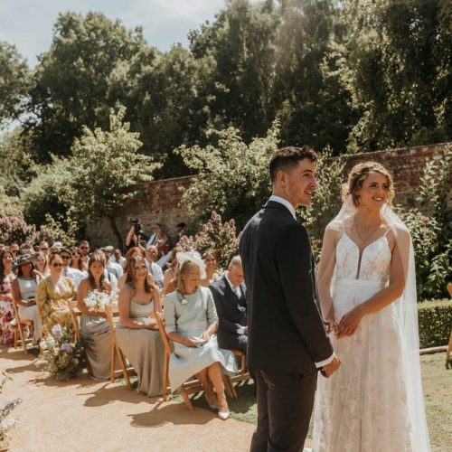 Bride-and-groom-at-front-of-walled-garden-ceremony