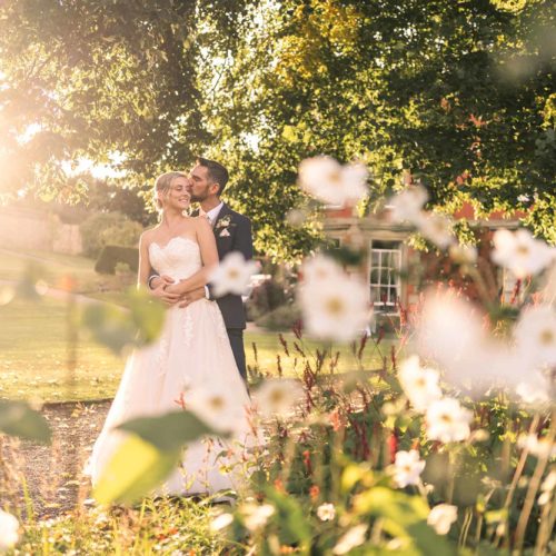 Bride-and-groom-in-evening-light-on-main-lawn-at-Homme-House