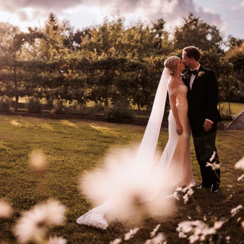 Bride-and-groom-kiss-in-evening-sunshine-in-Home-House-walled-garden
