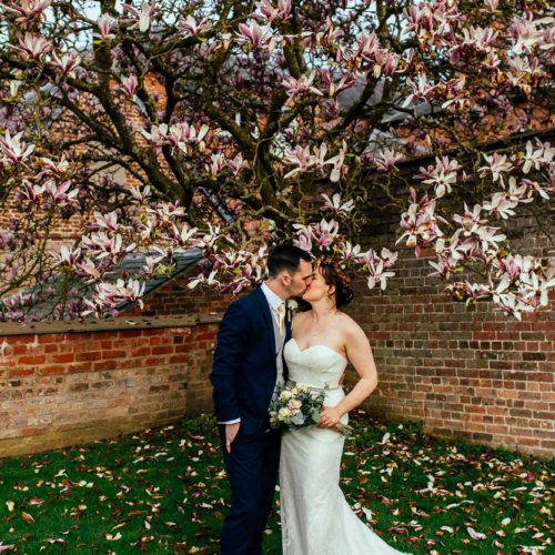 Bride-and-groom-kiss-under-magnolia-in-rose-garden-at-Homme-House