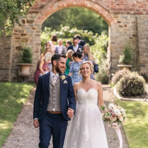 Bride-and-groom-leading-guests-through-Homme-House-garden