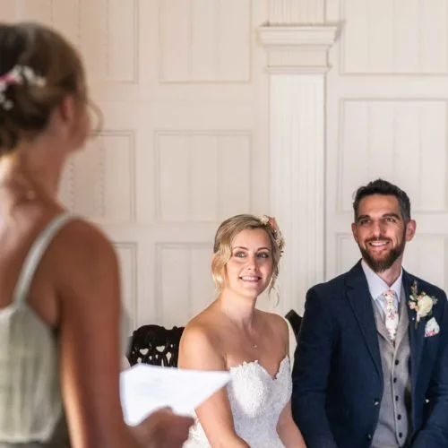 Bride-and-groom-listen-to-wedding-reading-in-Panelled-Room