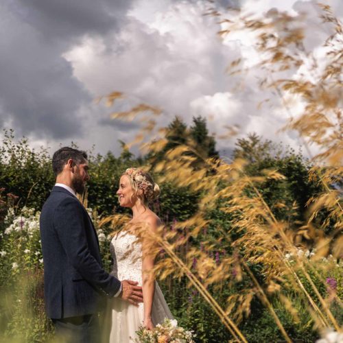 Bride-and-groom-portrait-in-garden-with-grasses-in-foreground