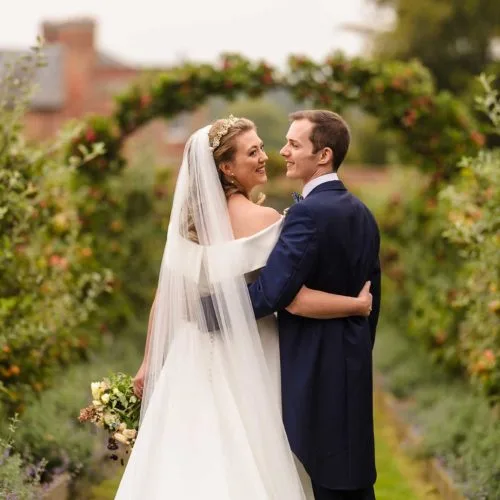 Bride-and-groom-portrait-on-espaliered-apple-tree-walkway