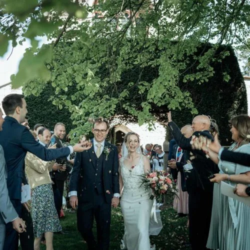 Bride-and-groom-showered-with-confetti-outside-St-Barthoomew's-Church-West-gate