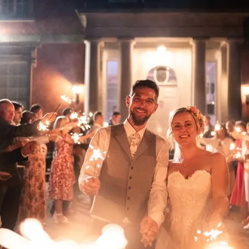 Bride-groom-and-guests-with-sparklers-outside-Homme-House