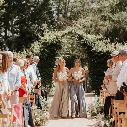 Bridesmaids-enter-outdoor-wedding-ceremony-space-at-Homme-House