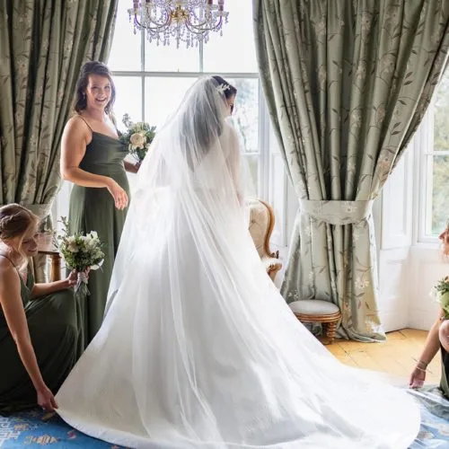 Bridesmaids-help-bride-with-dress-in-Homme-House-Bridal-Suite