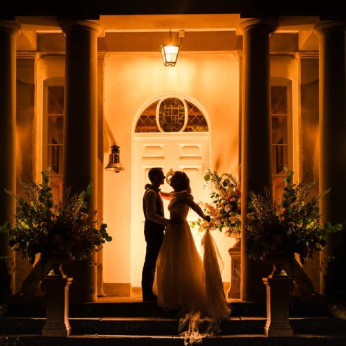 Evening-portrait-of-bride-and-groom-outside-Homme-House-front-door