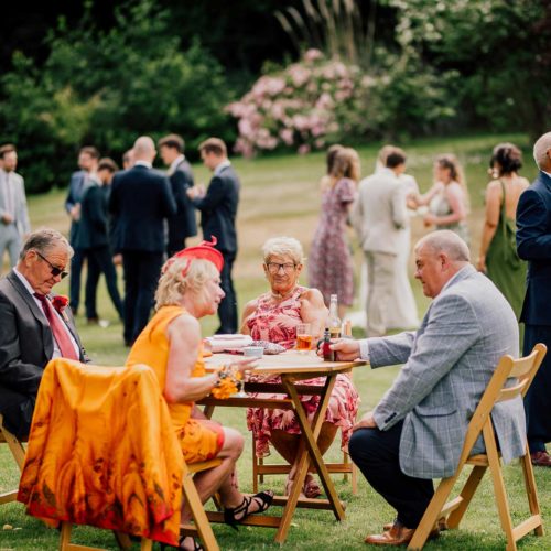 Guests-seated-at-wedding-reception-on-the-main-lawn-at-Homme-House