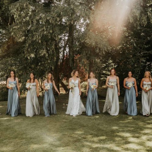 Portrait-of-bride-and-bridesmaids-walking-in-Homme-House-main-garden